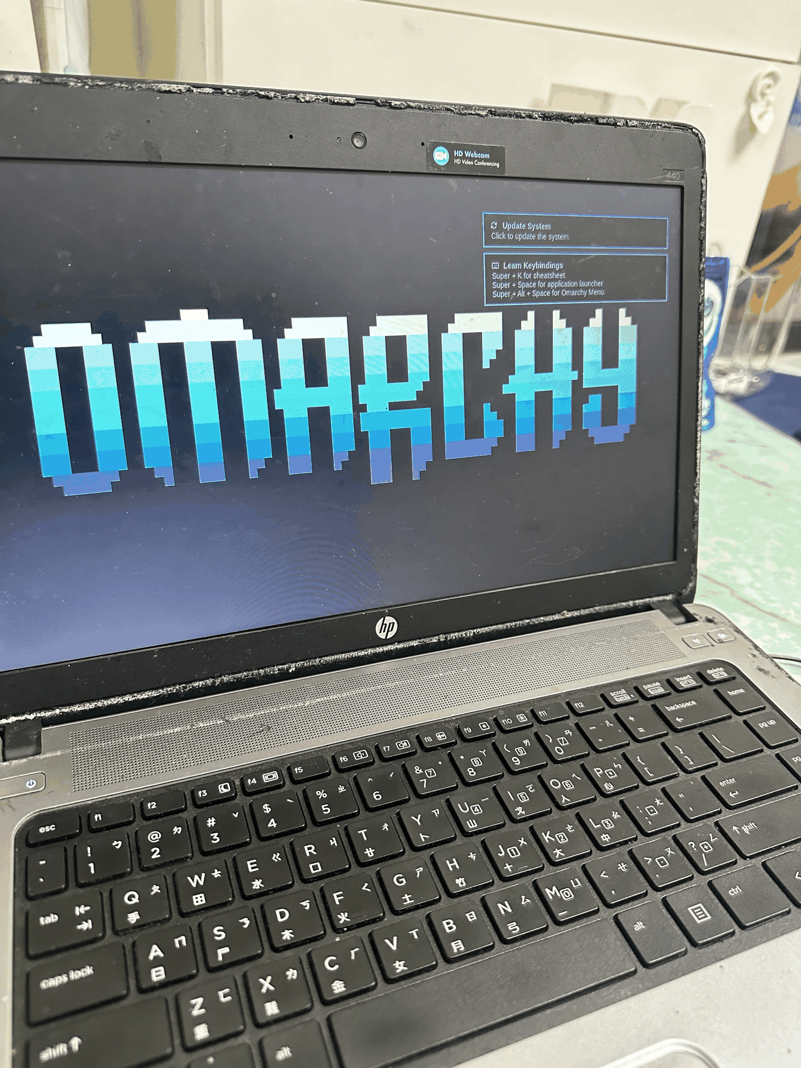 老筆電螢幕上顯示 OMARCHY 大字的開機畫面