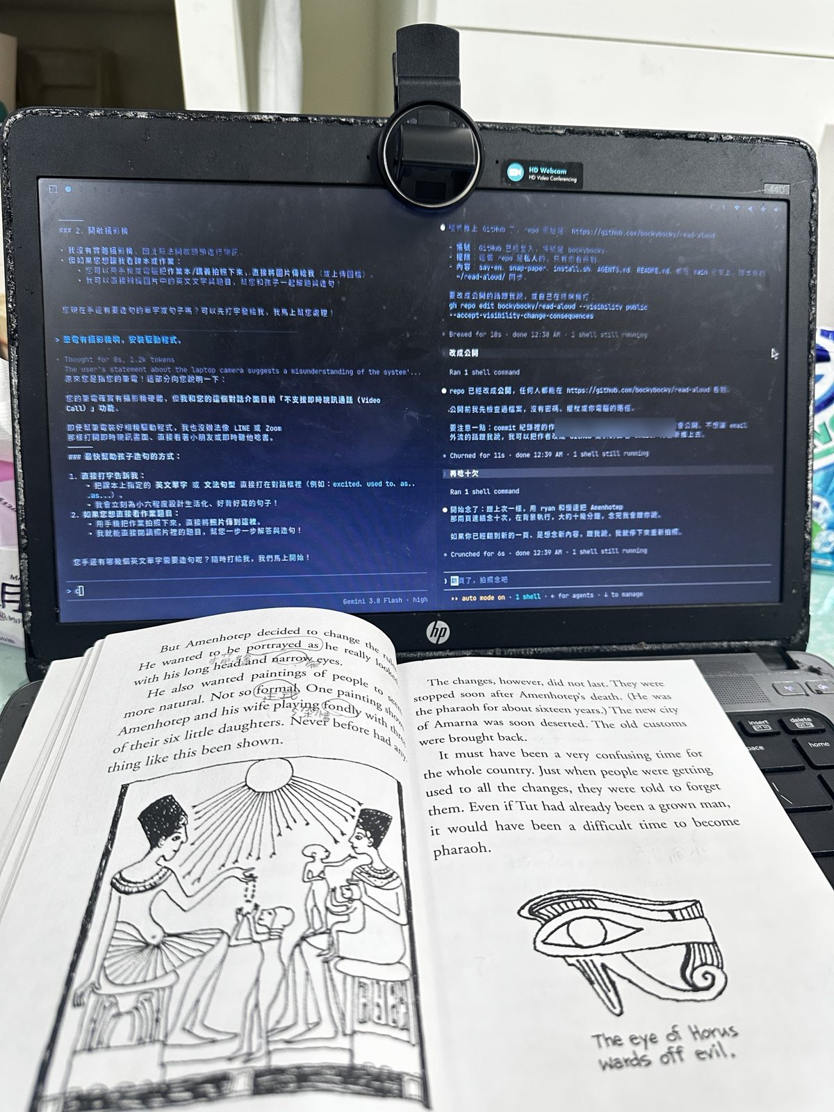 那天晚上的實景：舊筆電螢幕上方夾著網路攝影機，右邊視窗的 AI 正在用慢速念課文，筆電前面攤著那本古埃及讀本